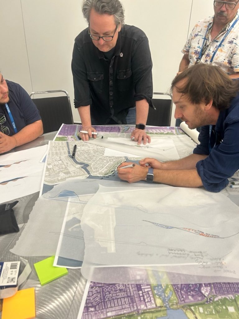 Four shortcourse workshop participants review materials with coastline maps.